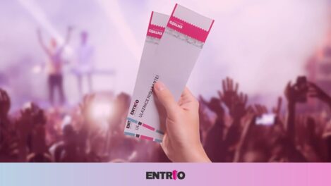 Hand holding concert tickets in a crowd